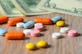 Assorted colored pills and money on the table. The concept of buying pills. The concept of increasing the price of tablets