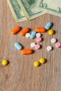 Assorted colored pills and money on the table. The concept of buying pills. The concept of increasing the price of tablets