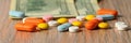 Assorted colored pills and money on the table. The concept of buying pills. The concept of increasing the price of tablets