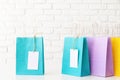 Assorted colored shopping bags with blank tags on white table Royalty Free Stock Photo