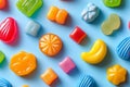 Assorted colorful candies creating a vibrant and playful pattern on a light blue backdrop