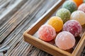 Assorted colorful mochi ice cream on a wooden tray