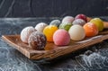Assorted colorful mochi ice cream on a wooden tray
