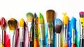 Assorted colorful paint brushes with vibrant streaks of paint on a white canvas background Royalty Free Stock Photo