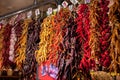 Assorted colorful varieties of hot and sweet dry peppers in the market. Rows of variety chili peppers hang together in Royalty Free Stock Photo