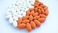 Assorted colorful white and orange pharmaceutical medicine pills on white background