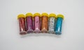 Assorted colors craft glitter in small tubes with yellow caps is