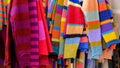 Assorted colors of woolen knitted off the shoulder clothes at the market of clothing homemakers. Selective focus.