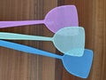 Assorted coloured fly swatters against a wooden background Royalty Free Stock Photo