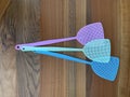 Assorted coloured fly swatters against a wooden background Royalty Free Stock Photo