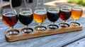 Assorted craft beer flight on wooden paddle at outdoor brew pub setting Royalty Free Stock Photo