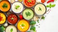 Assorted cream soups in bowls, traditional soups, ingredients for soup nearby, top view, bowls on a white background.