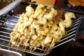 Assorted deep fried street food sold at a food cart along a sidewalk