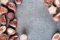 Assorted delicious chocolate pralines background on grey texture, place for text, product photography for patisserie