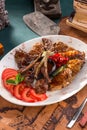 Assorted delicious grilled bbq meat with tomatoes on white plate on old map background Royalty Free Stock Photo