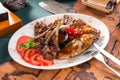 Assorted delicious grilled bbq meat with tomatoes on white plate on old map background Royalty Free Stock Photo