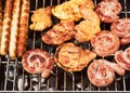 Assorted delicious grilled meat over the hot fire on a portable barbecue with steaks, sausages, chicken.