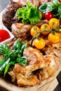 Assorted delicious grilled meat and vegetables with fresh salad and bbq sauce on cutting board on wooden background Royalty Free Stock Photo