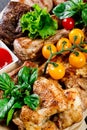 Assorted delicious grilled meat and vegetables with fresh salad and bbq sauce on cutting board on wooden background close up. Big