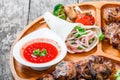 Assorted delicious grilled meat and vegetables with fresh salad and bbq sauce on cutting board on wooden background Royalty Free Stock Photo