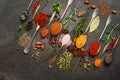 Assorted different bright colored spices, herbs, seasonings and seeds in spoons on a dark vintage background. Top view, flat lay, Royalty Free Stock Photo