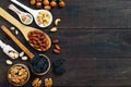 Assorted different nuts, prunes, pumpkin seeds in spoons on a dark wooden background. Royalty Free Stock Photo