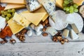 Assorted different types of cheeses with fruits, nuts, dried fruits