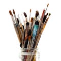 Assorted dirty painting brushes in glass flask Royalty Free Stock Photo