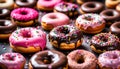 assorted donuts with chocolate frosted, pink glazed and sprinkles donuts.