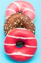 Assorted donuts with chocolate on light blue background Royalty Free Stock Photo