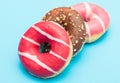 Assorted donuts with chocolate on light blue background Royalty Free Stock Photo