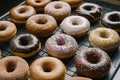 Assorted donuts displayed on kitchen table, tempting pastry delights