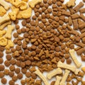 Assorted dry dog food scattered on a white surface. Includes bone-shaped biscuits Royalty Free Stock Photo