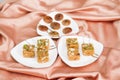 Assorted dry fruit Indian sweets with dry figs in three plates on a satin fabric