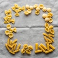 Assorted dry pasta shapes are arranged in a circular pattern on a gray Royalty Free Stock Photo