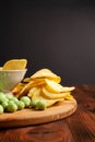 Assorted dry snacks on a wooden board. Chips, peanuts, croutons, wasabi Royalty Free Stock Photo