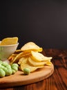 Assorted dry snacks on a wooden board. Chips, peanuts, croutons, wasabi Royalty Free Stock Photo