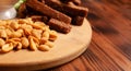 Assorted dry snacks on a wooden board. Chips, peanuts, croutons, wasabi Royalty Free Stock Photo