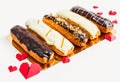 Assorted eclairs on a gold substrate on a white background Royalty Free Stock Photo