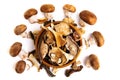 Assorted edible dried mushrooms in a wooden bowl isolated on a white background