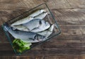 Fresh fish in glass tray over wooden background. Top view. Royalty Free Stock Photo