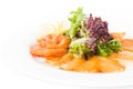 Assorted fish on a plate with lettuce and lemon on a white background. A plate of fish assorted . close up