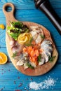 Assorted fish slices on a board. On a blue, wooden background Royalty Free Stock Photo