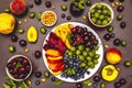 Assorted fresh berries of a cherry, gooseberry, blueberries, slices of ripe peach, plum and apricot, fragrant mint on a plate Royalty Free Stock Photo