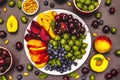 Assorted fresh berries of a cherry, gooseberry, blueberries, slices of ripe peach, plum and apricot, fragrant mint on a plate Royalty Free Stock Photo