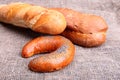 Assorted fresh breads isolated on old sackcloth. Royalty Free Stock Photo