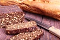 Assorted fresh breads, slice and knife isolated on old wood table.