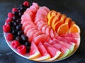 Assorted Fresh Fruit Platter with Berries, Citrus, and Melon Slices on Dark Background for Healthy Eating Concept Royalty Free Stock Photo