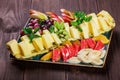 Assorted fresh fruits on plate. Apple, grapes, kiwi, pineapple, grapefruit, orange