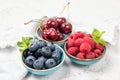 Assorted fresh juicy berries. Cherry, blueberry and raspberry in bowls Royalty Free Stock Photo